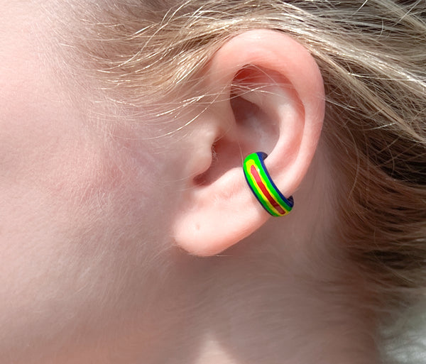 Chunky rainbow ear cuff on ear. colors : blue, green, yellow and red