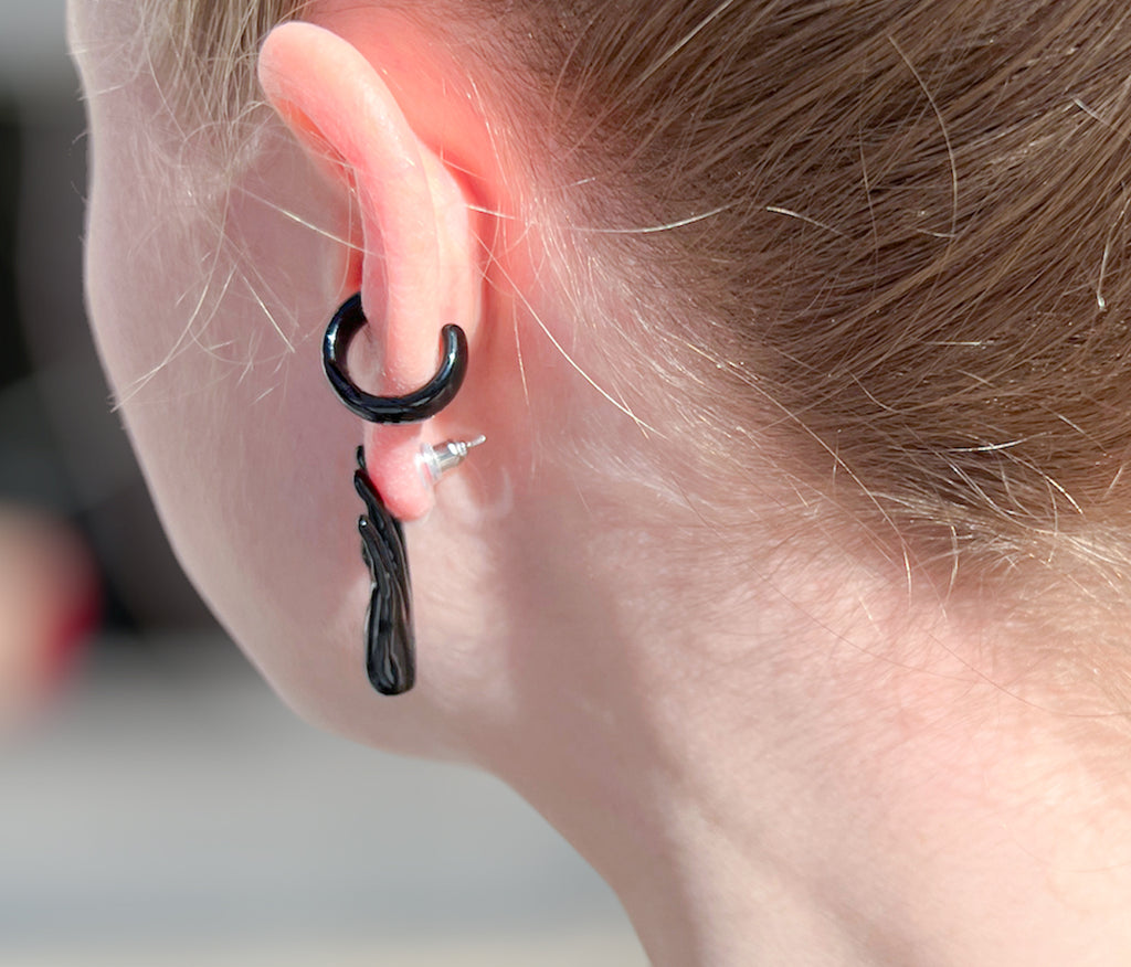 Chunky goth black ear cuff on ear with goth black hand stud earring. Hand-painted enamel.